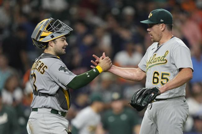 Oakland Athletics catcher Shea Langeliers and relief pitcher Trevor May celebrate after a game against the Houston Astros Tuesday, Sept. 12, 2023, in Houston. The Athletics won 6-2. (David J. Phillip / ASSOCIATED PRESS)