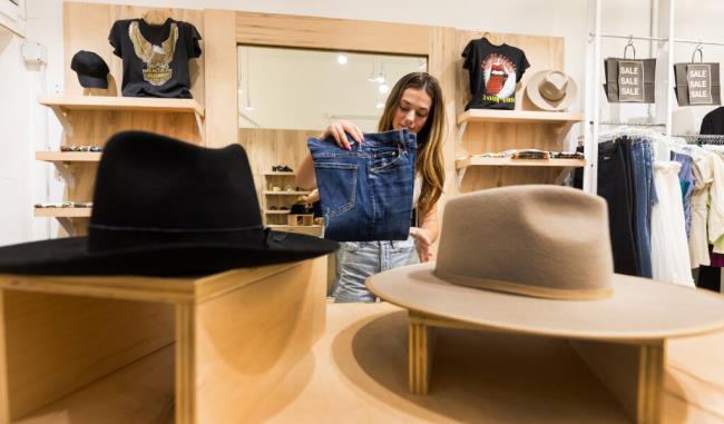 Willow Harm folds a pair of jeans at Punch Clothing in Downtown Santa Rosa Wednesday, July 26, 2023. (Photo by John Burgess/The Press Democrat)