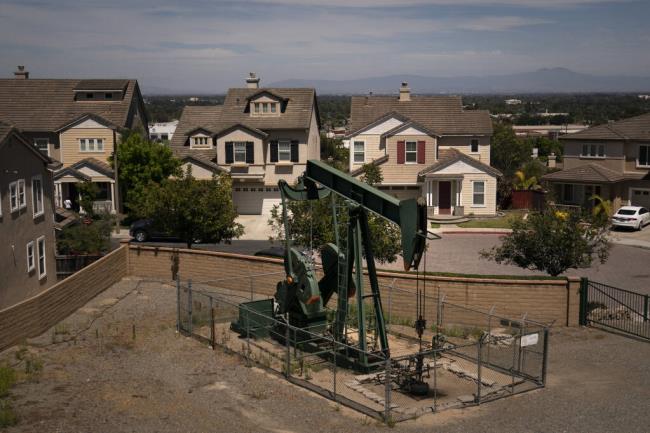 FILE - A pump jack extracts oil at a drilling site next to homes June 9, 2021, in Signal Hill, Calif. Enviro<em></em>nmental advocates in California will try to enshrine a law banning new gas and oil wells near homes, schools and hospitals in a move that comes as the oil industry is vying for voters to overturn it. (AP Photo/Jae C. Hong, File)