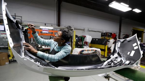 Mary Skinner inspects the rear end of a General Motors Chevrolet Cruze at Jamestown Industries in Youngstown, Ohio on Nov. 28, 2018. U.S. automakers and parts manufacturers have added nearly 90,000 jobs since January 2020 but it's hard to tease out just which eco<em></em>nomic gains can be credited to USMCA and which happened for a variety of unrelated reasons. (AP Photo/Tony Dejak, File)