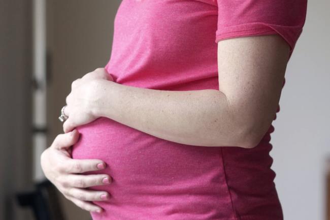 FILE - A pregnant woman stands for a portrait in Dallas, Thursday, May 18, 2023. On Friday, Aug. 4, 2023, U.S. health officials approved the first pill, Zurzuvae, specifically intended to treat severe depression after childbirth, a co<em></em>ndition that affects thousands of new mothers in the U.S. each year. (AP Photo/LM Otero, File)